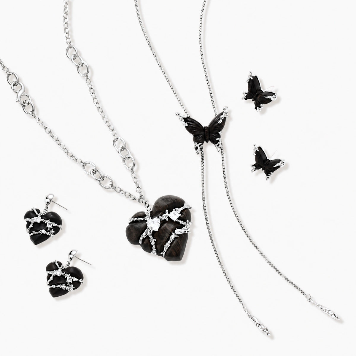 Dark wood butterfly earrings and necklace with silver chain accents on white background, showing natural grain texture.