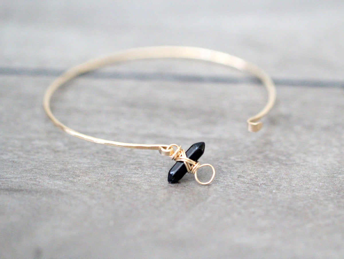 Obsidian crest bracelet with polished black stone beads and silver crest charm on wrist