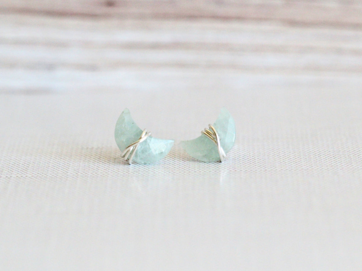 Aquamarine stud earrings displayed flat, showing the moon and star design