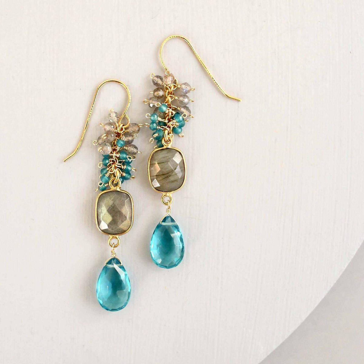 Bezel Cluster EarringsDripping in gems, these long gemstone drop earrings are a handmade combination of beautiful bezel set stones and clusters of gems.- 2.5" long- French hooks- 14k goldEarringsPARKEN JEWELRYVettedArcBezel Cluster Earrings