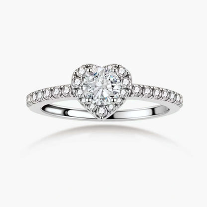 Heart-shaped halo ring with brilliant moissanite center stone surrounded by smaller crystals in sterling silver setting