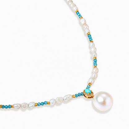 Beaded necklace with baroque pearls, turquoise stones, and gold accents featuring a large pearl pendant on white background.