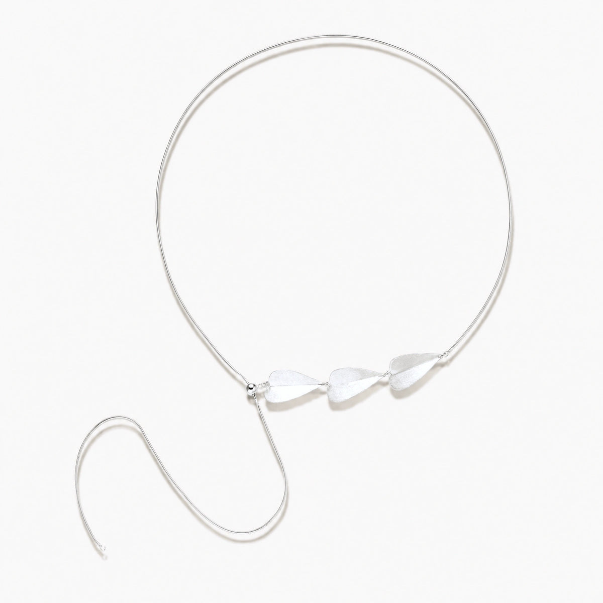 Minimalist sterling silver necklace with three brushed leaf-shaped pendants on delicate chain against white background