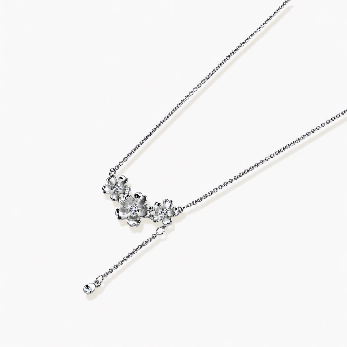 White gold plated Y-shaped necklace with three dimensional flower charms and adjustable drop pendant