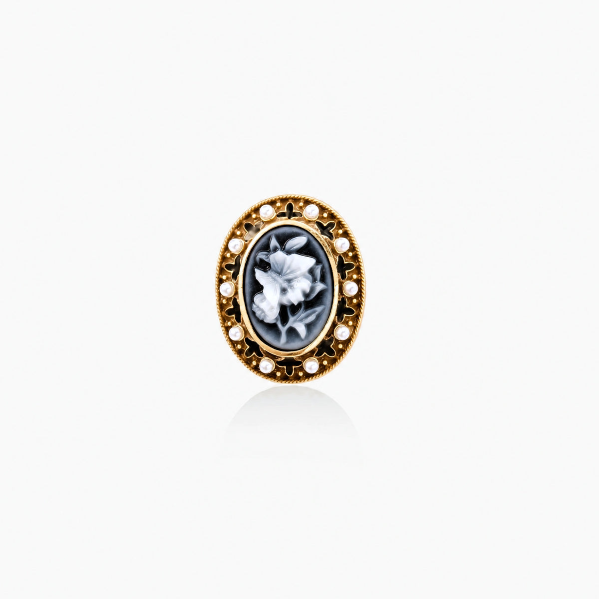 Gold-plated ring with oval blue floral cameo, pearl accents, and black enamel detailing on white background.