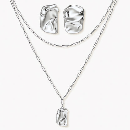 Modern textured hoop earrings and layered chain necklace with liquid metal pendant in silver and gold finishes.