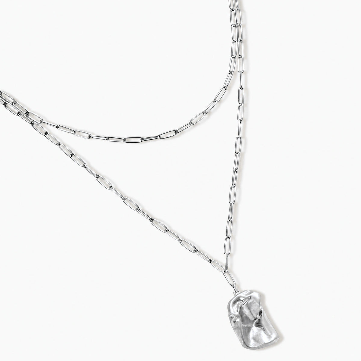 Modern textured hoop earrings and layered chain necklace with liquid metal pendant in silver and gold finishes.