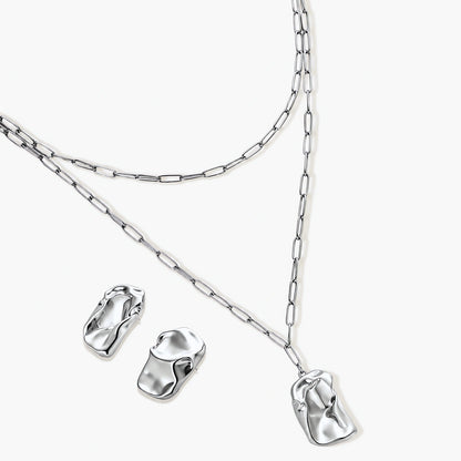 Modern textured hoop earrings and layered chain necklace with liquid metal pendant in silver and gold finishes.