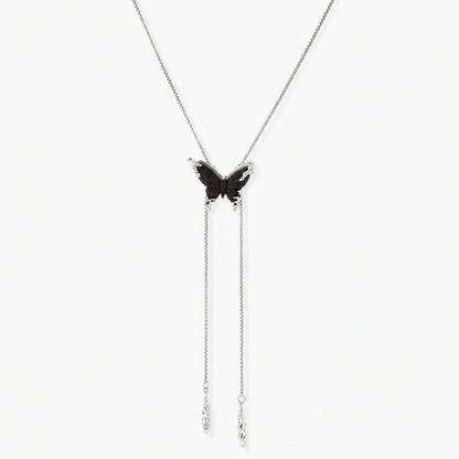 Dark wood butterfly earrings and necklace with silver chain accents on white background, showing natural grain texture.