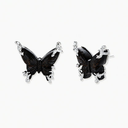 Dark wood butterfly earrings and necklace with silver chain accents on white background, showing natural grain texture.