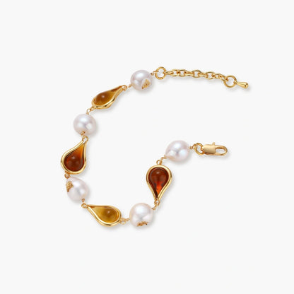 Gold plated bracelet with amber and honey teardrop stones, baroque freshwater pearls with gold flecks, and an adjustable chain.