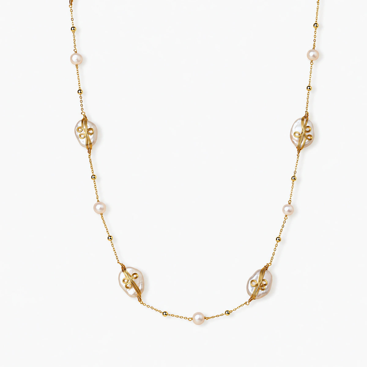 Long gold chain necklace with baroque pearls wrapped in leaf designs and small freshwater pearls spaced along the strand