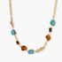 Gold plated eco-brass chain necklace with turquoise nuggets, amber-toned stones, brown discs and molten gold accents on cream.