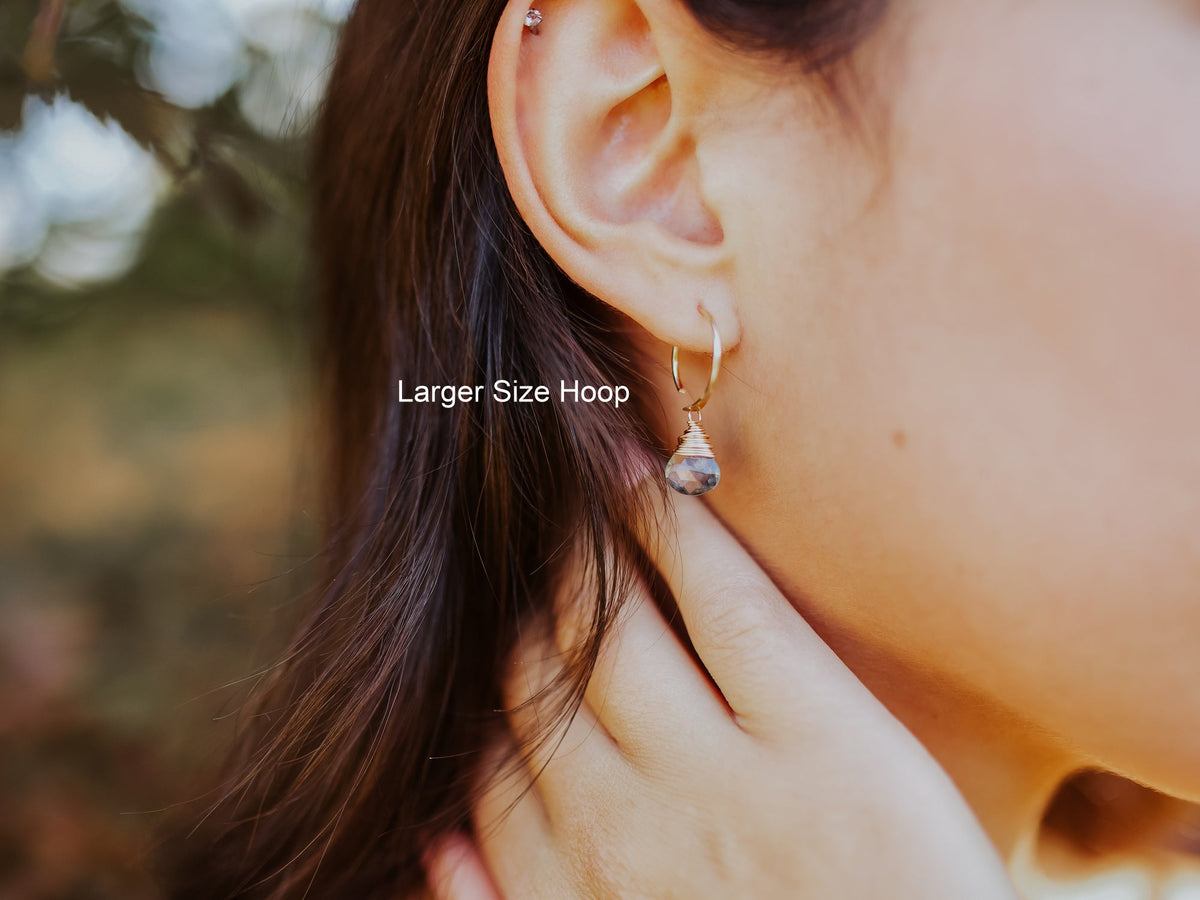 Pair of moss aquamarine dangle hug earrings showing faceted green stone drops