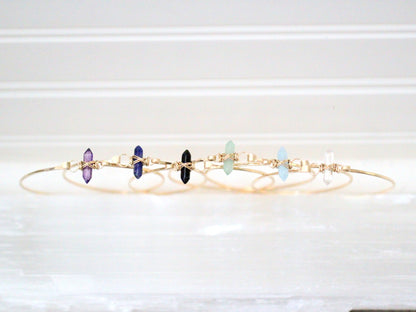 Obsidian crest bracelet styled flat, showing dark gemstone beads and crest detail