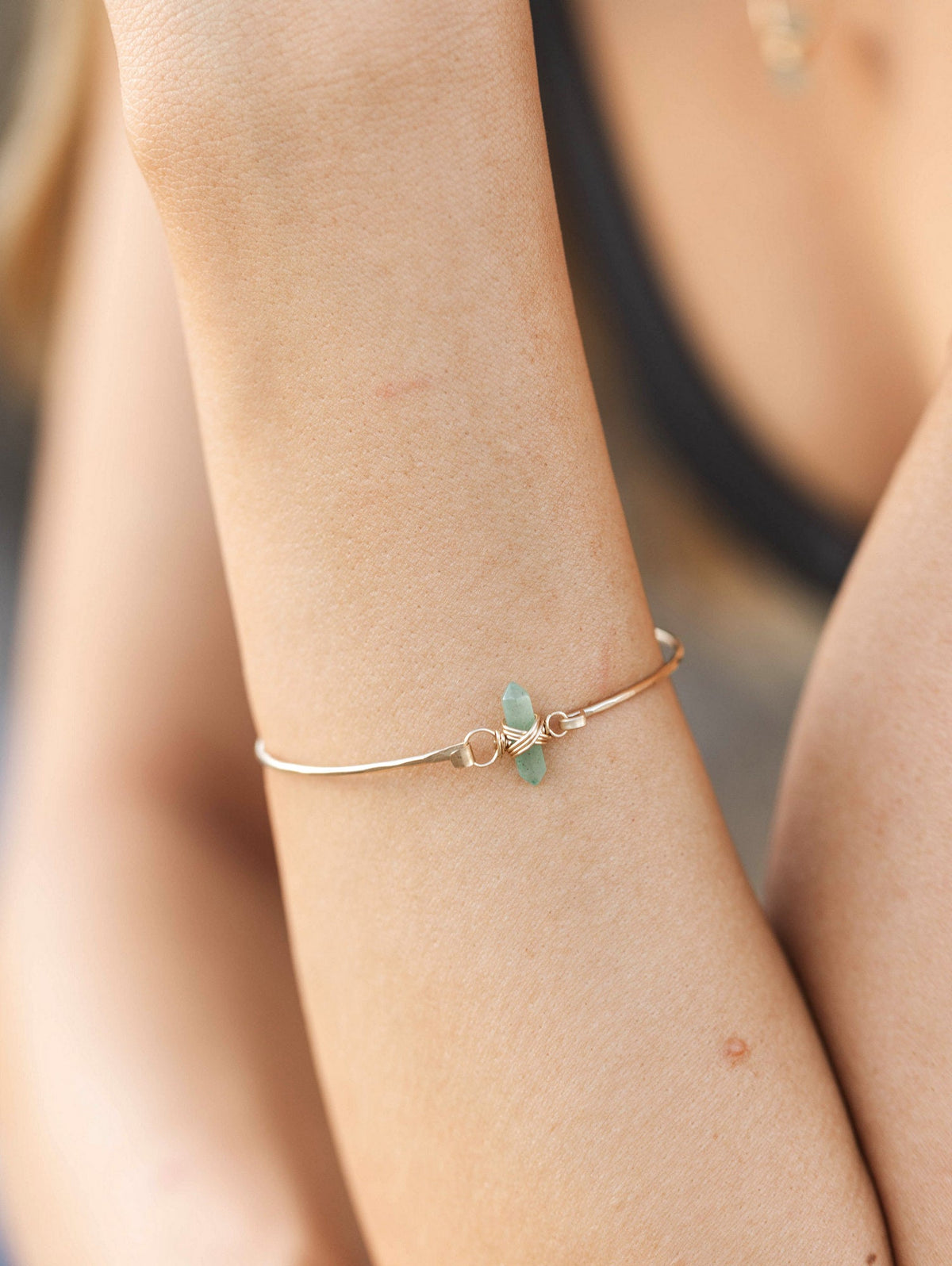 Close-up of an obsidian crest bracelet, dark stone beads on the wrist for a bold minimal look