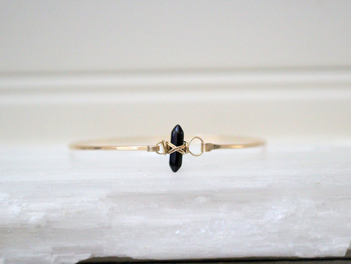Obsidian crest bracelet with black polished stone beads and a crest accent, unisex design