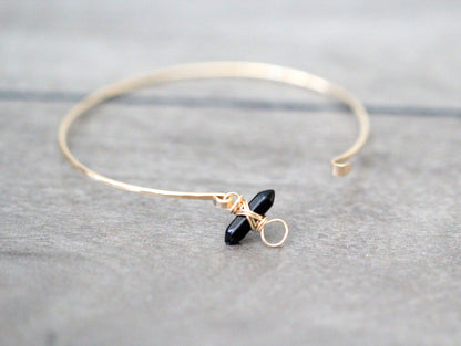 Obsidian crest bracelet with polished black stone beads and silver crest charm on wrist