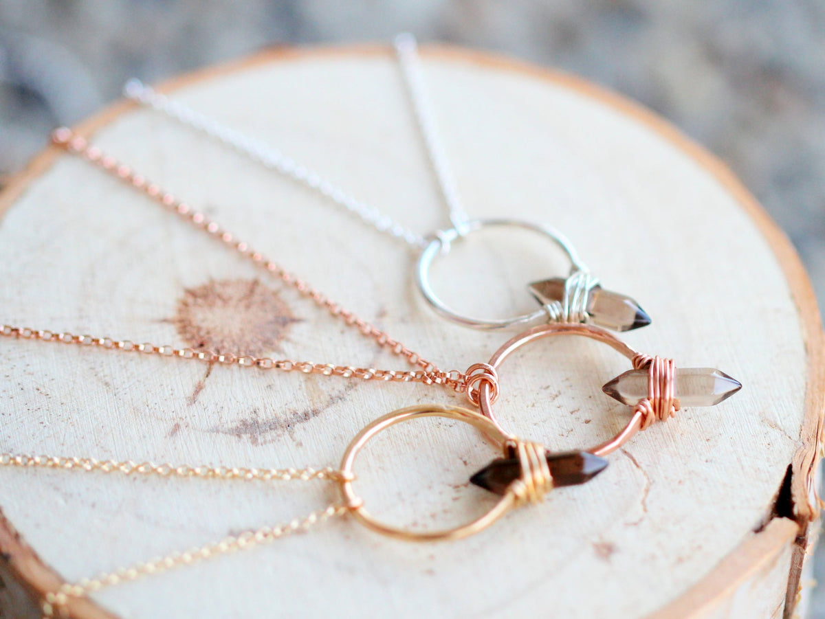 Smoky quartz pendant necklace with crest design, close-up of translucent stone