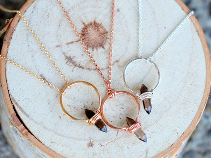 Smoky quartz crest necklace close-up, translucent brown gem and chain links