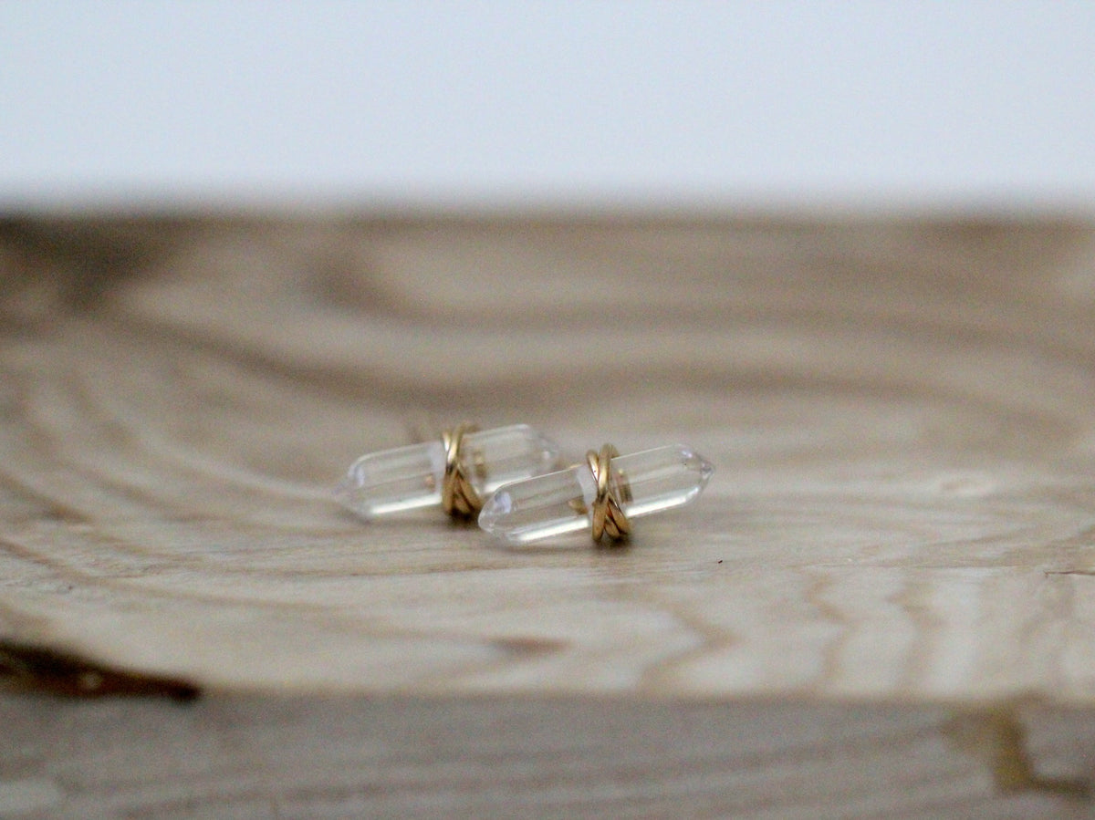 Clear crystal-like objects with gold bands on a wooden surface