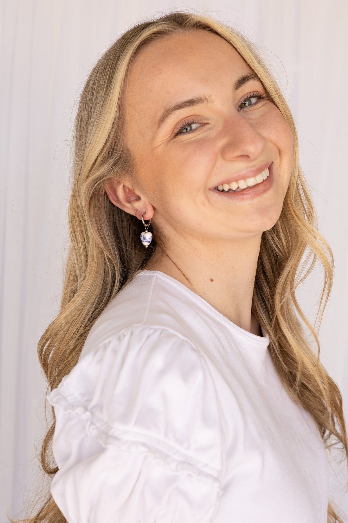 Close-up of a blue hoop earring highlighting the glossy finish