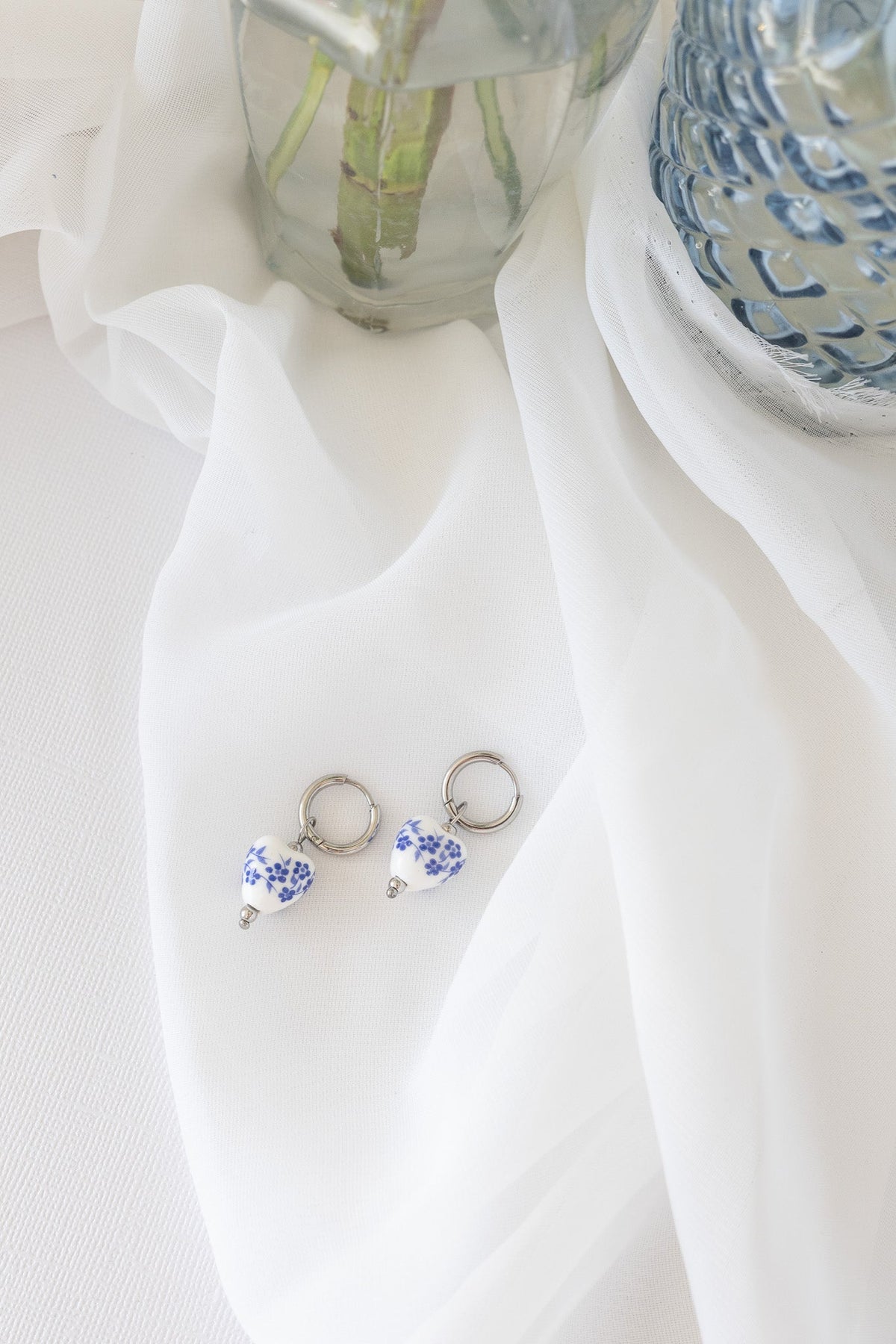 Blue hoop earring with light reflecting off the smooth surface