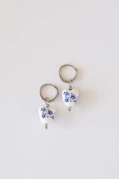 Blue hoop earring worn on an ear, showing size and fit