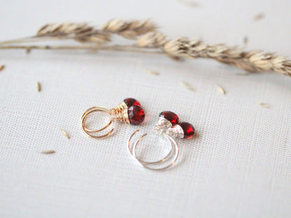 Garnet dangle hug earrings detail, gold hoop with a dangling garnet stone for a subtle pop of color