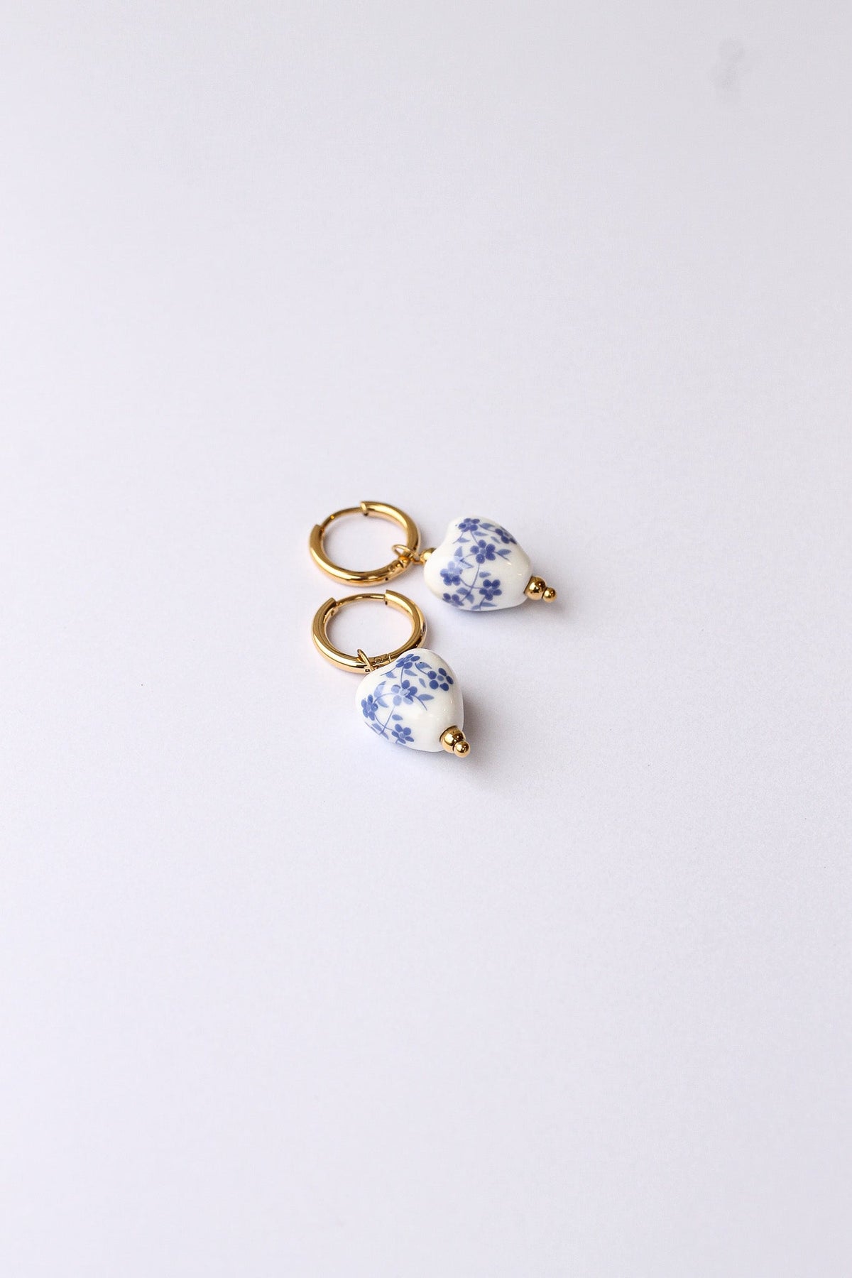 Blue hoop earring resting on a neutral background