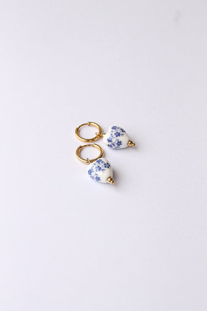 Blue hoop earring resting on a neutral background