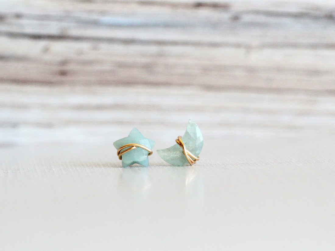 Aquamarine stud earrings with a moon and star motif, shown as a pair
