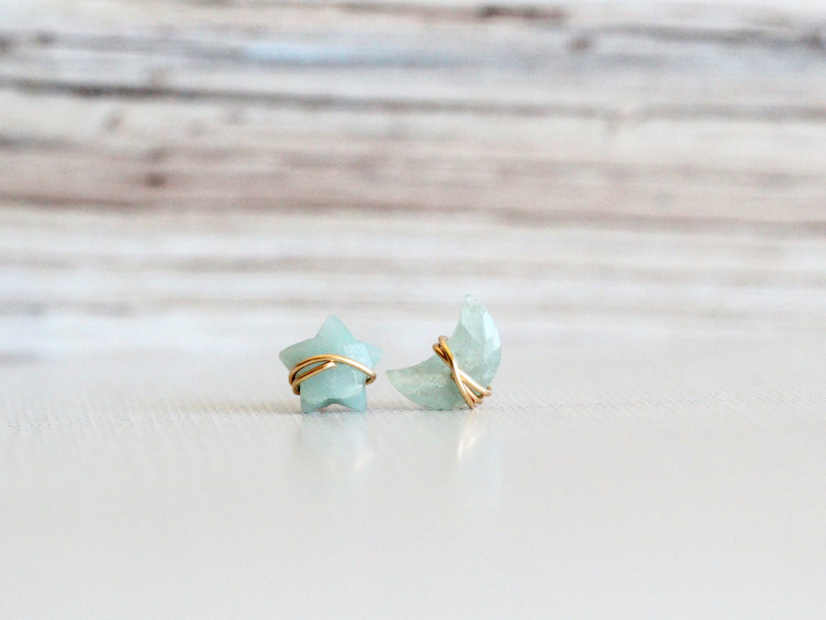 Aquamarine stud earrings with a moon and star motif, shown as a pair
