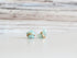 Aquamarine stud earrings with a moon and star motif, shown as a pair