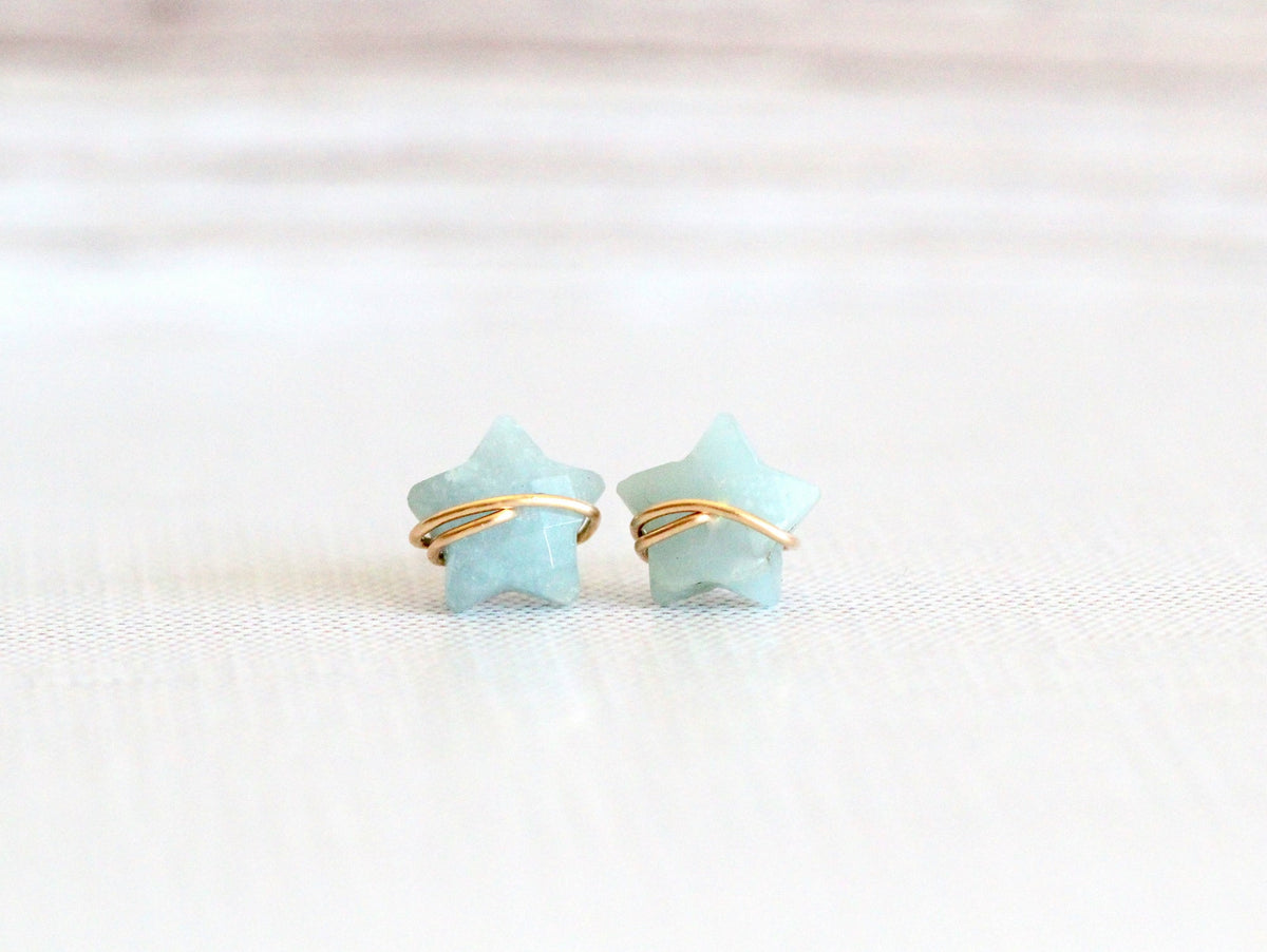 Close-up of aquamarine stud earrings showing the light blue stones