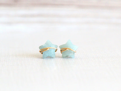 Close-up of aquamarine stud earrings showing the light blue stones