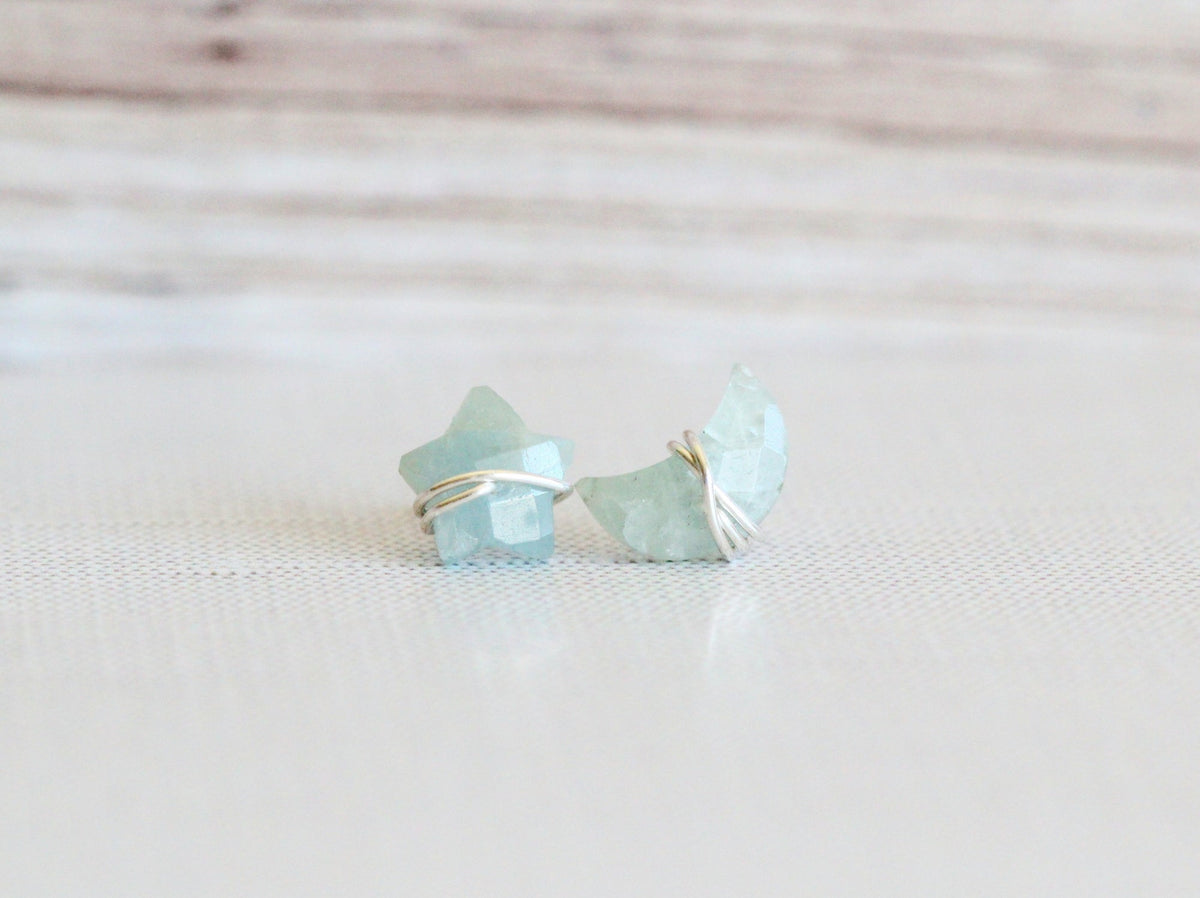 Aquamarine stud earrings worn on an ear for scale