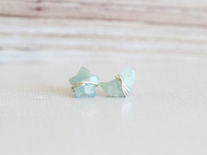 Aquamarine stud earrings worn on an ear for scale