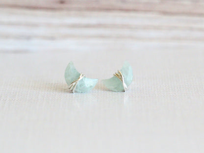 Aquamarine stud earrings displayed flat, showing the moon and star design