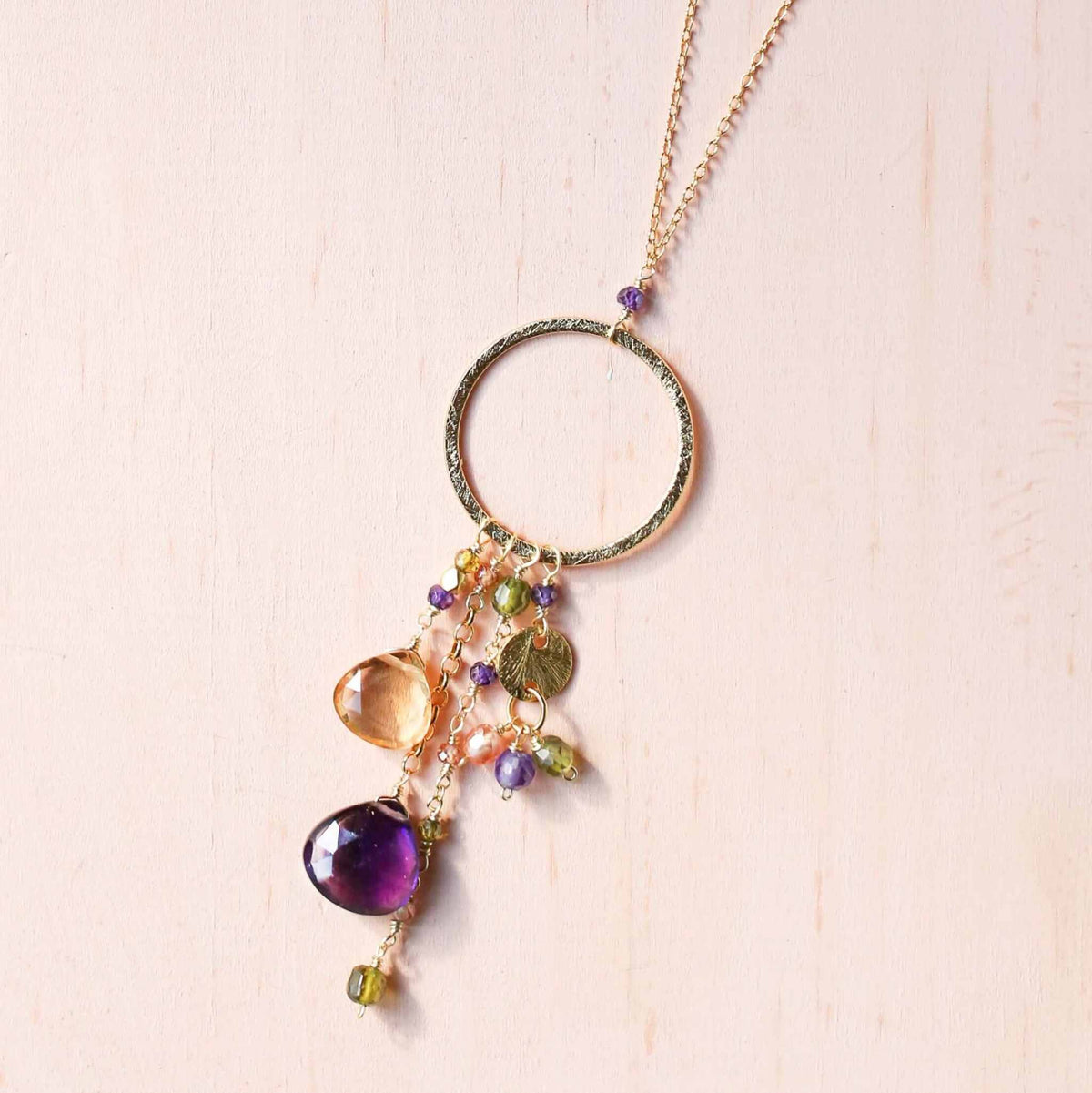The Ammil Necklace - Amethyst &amp; CitrineThe ultimate gemstone pendant. Multiple strands of glimmering amethyst, citrine and peridot gemstones hang from our signature gold circle. Handmade with 14k gold plaNecklacesPARKEN JEWELRYVettedArcThe Ammil Necklace