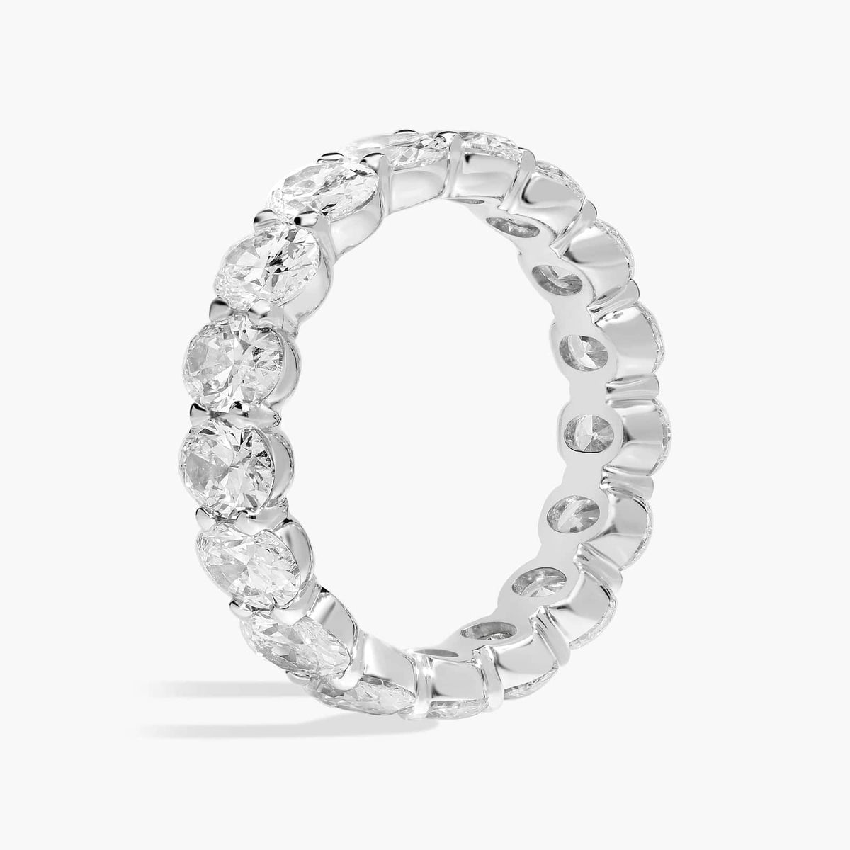 Oval moissanite eternity band ring in white gold overlay, close-up of stones