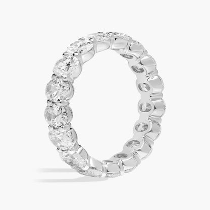 Oval moissanite eternity band ring in white gold overlay, close-up of stones