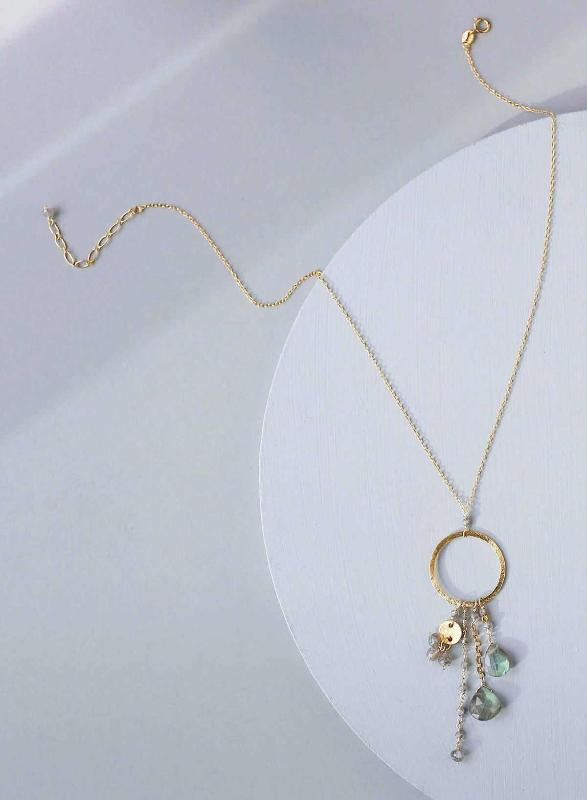 The Ammil Necklace featuring a lush labradorite gemstone pendant with multiple gemstone strands on a 14k gold plated hoop, handmade in New York City.