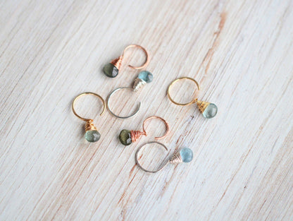 Moss aquamarine dangle hug earrings styled flat lay showing gold hoop and green drop