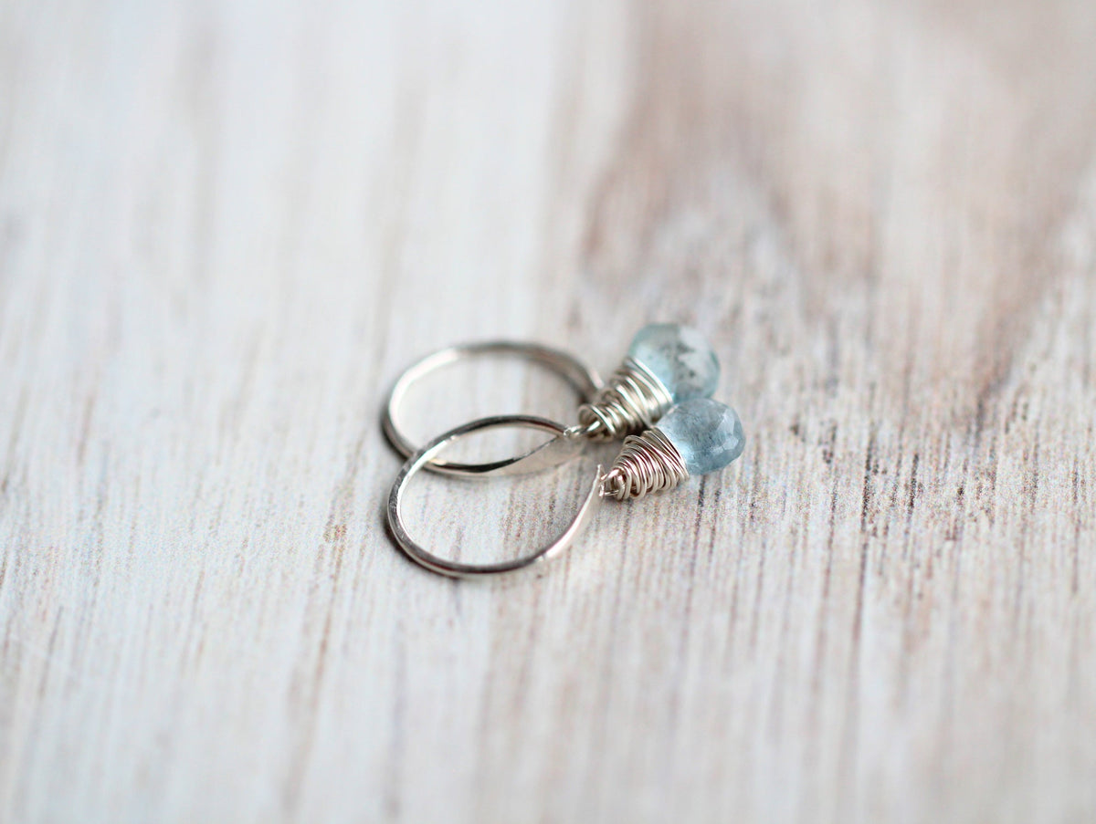 Side view of moss aquamarine dangle hug earrings with gold hoop and dangling stone
