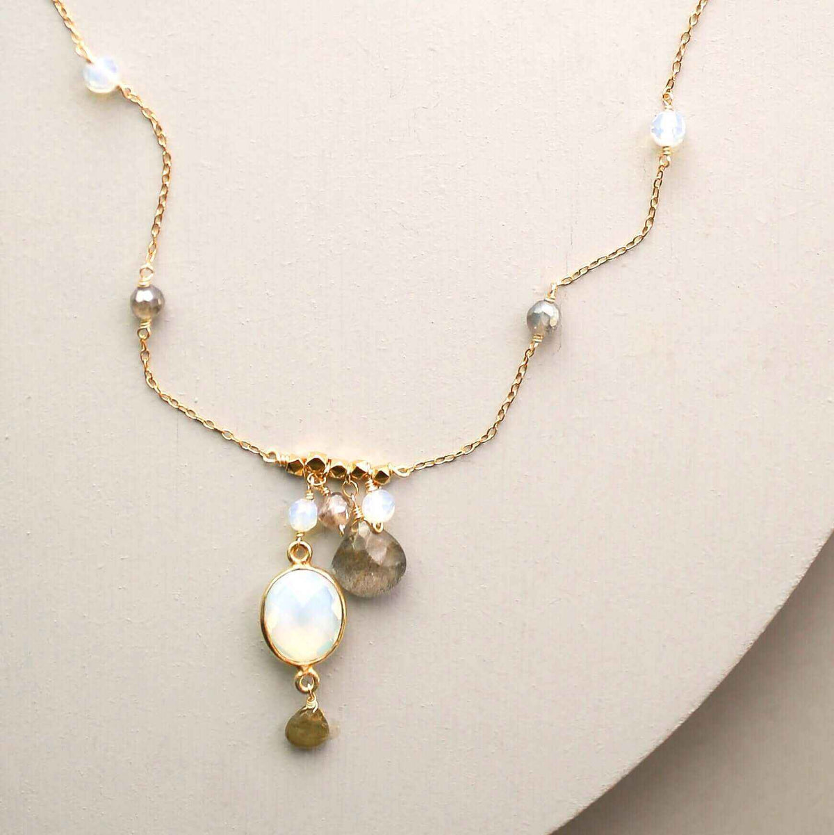 Opalite bezel necklace with gold chain and labradorite accents on white background