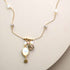 Opalite bezel necklace with gold chain and labradorite accents on white background